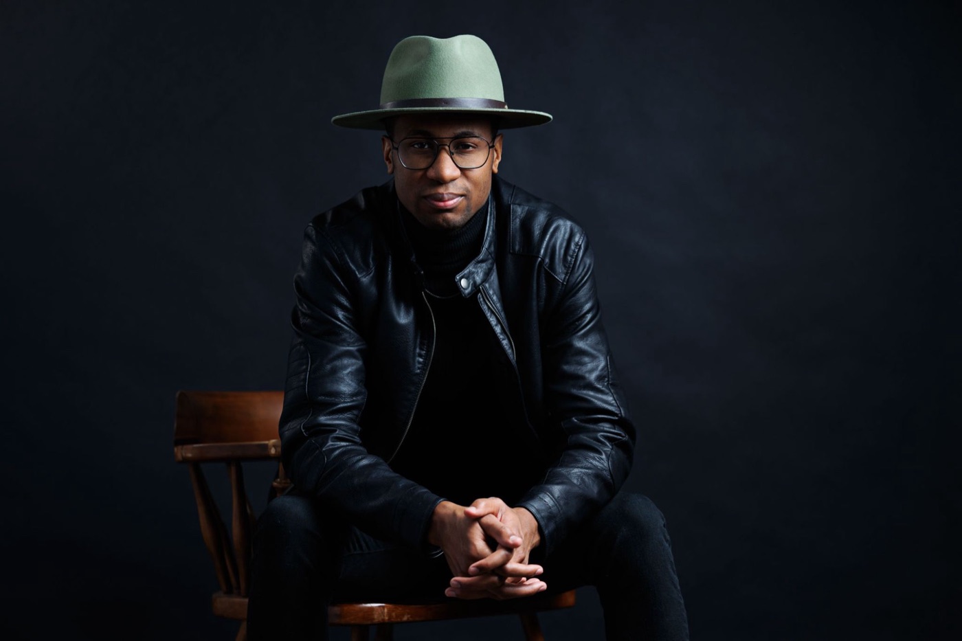 Quentin Allums in a green hat and leather jacket